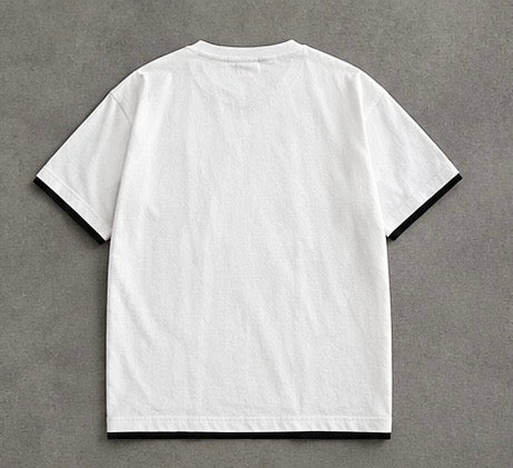 A white short-sleeve t-shirt with black contrast trim on the collar, sleeve cuffs, and hem, laid flat on a textured gray background.